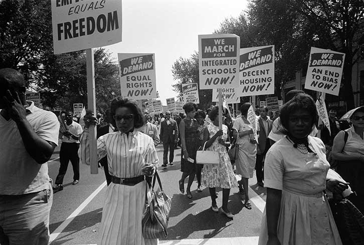 1963年8月28日、自由と平等を求めるプラカードを手に20万人がワシントンD.C.へ行進した
